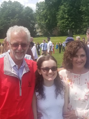 Kelly Coons in a white dress at her high school graduation with her grandparents, William Coons Jr. and Becky Coons.